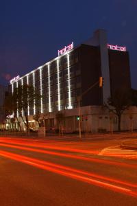 un hotel con letreros de neón en la parte superior de un edificio en Aston Hotel en Bratislava