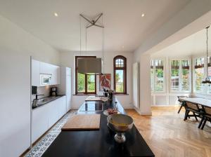 a kitchen with white cabinets and a black counter top at Villa Boddenwacht in Ahrenshoop +22 photos