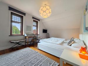 a bedroom with two beds and a table and a desk at Villa Boddenwacht in Ahrenshoop