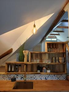 a kitchen with wooden shelves and a sink at The hayloft in Grohoţele