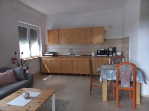 a living room with a kitchen and a table at Budai Garden House in Hévíz +14 photos