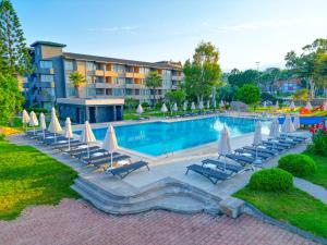 a swimming pool with lounge chairs and umbrellas at Senza Sunset Beach Hotel in Alanya +48 photos