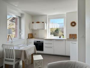a kitchen with white cabinets and a table and a window at Gîte Théophile Fenal in Badonviller