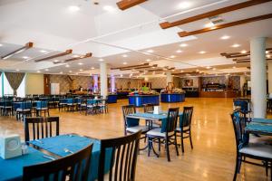 a dining room with blue tables and chairs at Senza Sunset Beach Hotel in Alanya