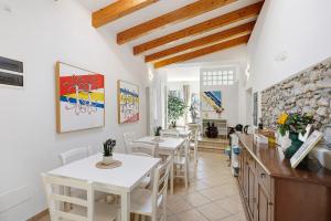 a dining room with tables and chairs and a stone wall at Rosa Di Mare Guest House in Finale Ligure