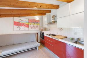 a kitchen with red and white cabinets and a sink at Rosa Di Mare Guest House in Finale Ligure +38 photos