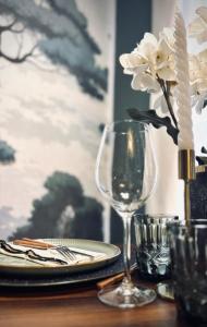 a table with a wine glass and a plate at La Suite Archevêché by Collection Signature - Hypercentre Albi - Parking inclus in Albi +18 photos