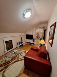 a living room with a couch and a tv at MÐM Duplex Apartment in Podgorica