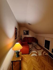 a living room with a red couch and a table at MÐM Duplex Apartment in Podgorica +18 photos