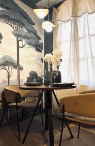 a dining room with a table with flowers and chairs at La Suite Archevêché by Collection Signature - Hypercentre Albi - Parking inclus in Albi