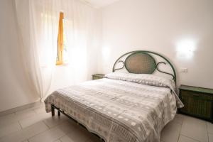 a bedroom with a bed with a white comforter and a window at Villa Chiara Infinity Sea View in Mandaradoni