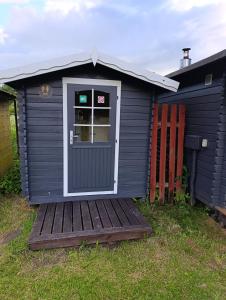 a blue shed with a door and a deck at Kolkja Holiday Centre -Kolkja Puhkeküla in Kolkja
