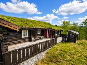 a log cabin with a deck with a grass roof at Large, cozy, and spacious cabin in Geilo, Kikut in Geilo