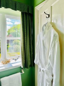 a robe hanging on a rack next to a window at Garwood House in Holt +21 photos