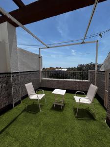 a patio with two chairs and a table on a balcony at Brisa de Pinares in Barbate