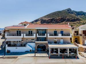a large apartment building with a mountain in the background at Filoxenia Hotel Monemvasia in Monemvasia