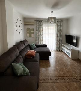 a living room with a couch and a television at Brisa de Pinares in Barbate
