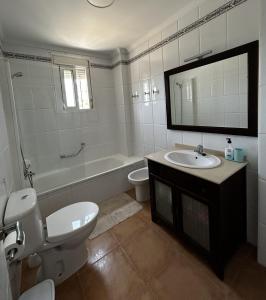 a bathroom with a toilet and a sink and a tub at Brisa de Pinares in Barbate +6 photos