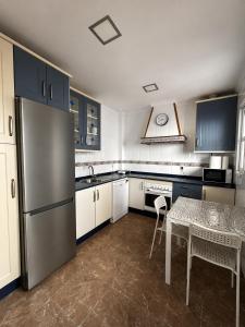 a kitchen with a table and a stainless steel refrigerator at Brisa de Pinares in Barbate