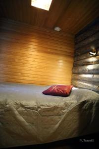 a bed in a room with a wooden wall at Holidayhome Sompio in Luosto