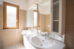 a white bathroom with a sink and a mirror at Villa Chiara Infinity Sea View in Mandaradoni