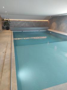 a swimming pool in a house with blue water at Westdiep 602 zeezicht, verwarmd binnenzwembad in De Panne