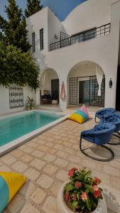 a villa with a swimming pool and a house at Kefia house in Hammamet Nord