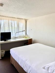 a hotel room with a bed and a sink at Campanile Valence Sud in Valence