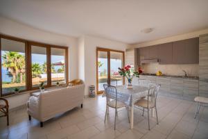 a kitchen and dining room with a table and chairs at Villa Chiara Infinity Sea View in Mandaradoni