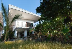a white house with a balcony and trees at Sam Lanta in Ko Lanta