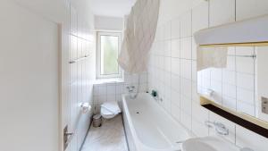 a white bathroom with a tub and a sink at Charming 3 Bedroom Retreat in Zurich