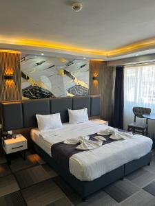 a bedroom with a large bed with a painting on the wall at Lizbonia Suit Otel in Istanbul