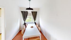 a dining room with a table and chairs and a window at Charming 3 Bedroom Retreat in Zurich