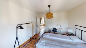 a white bedroom with two beds and a desk at Charming 3 Bedroom Retreat in Zurich