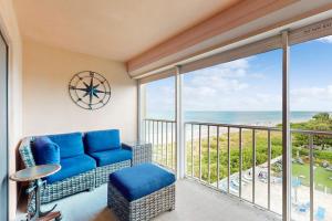 a balcony with a blue couch and a view of the ocean at Reef Club 401 in Clearwater Beach