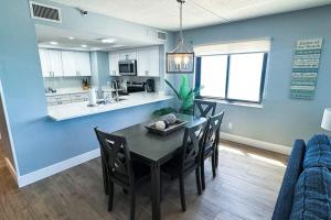 a dining room and kitchen with a table and chairs at Reef Club 401 in Clearwater Beach