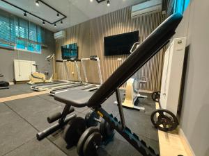 a gym with a bench and weights in a room at Whitealcyone Fit & Zen Apartment in Artemida +20 photos