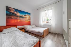 a bedroom with two beds and a painting on the wall at KRAB 2 in Rewal