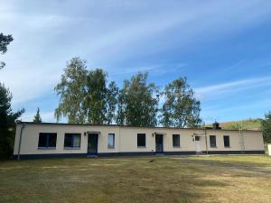Ein großes weißes Gebäude mit Bäumen im Hintergrund in der Unterkunft Boutique-Stay in Eberswalde-Finow