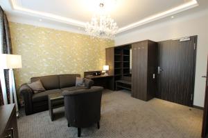 a living room with a couch and a desk at Hotel Europäischer Hof in Elsterwerda +32 photos