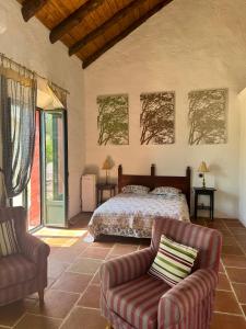 a bedroom with a bed and two chairs at Palacio de Montellano in Montellano +62 photos