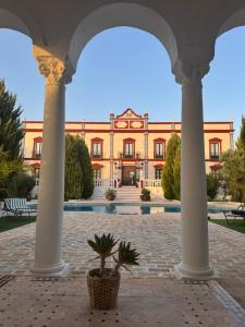 a building with columns and a potted plant in front at Palacio de Montellano in Montellano