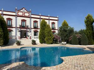 a house with a swimming pool in front of a building at Palacio de Montellano in Montellano