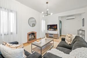 a living room with a couch and a fireplace at Melia Villa II by Nomads in Kissonerga