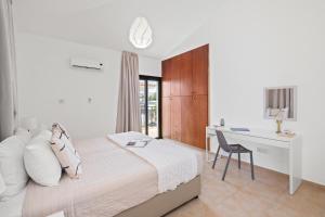 a bedroom with a bed and a desk with a chair at Melia Villa II by Nomads in Kissonerga +17 photos