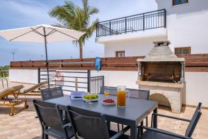 a patio with a table and a pizza oven at Melia Villa II by Nomads in Kissonerga