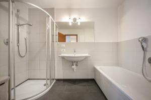 a bathroom with a sink and a shower and a bath tub at Apartments Villa Jim in Ortisei