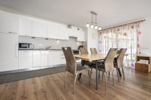 a kitchen and dining room with a wooden table and chairs at Apartments Villa Jim in Ortisei +9 photos