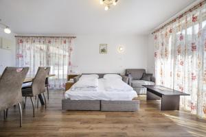 a bedroom with a bed and a table and chairs at Apartments Villa Jim in Ortisei