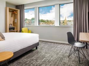 a hotel room with a bed and large windows at Mercure Newport in Newport +147 photos